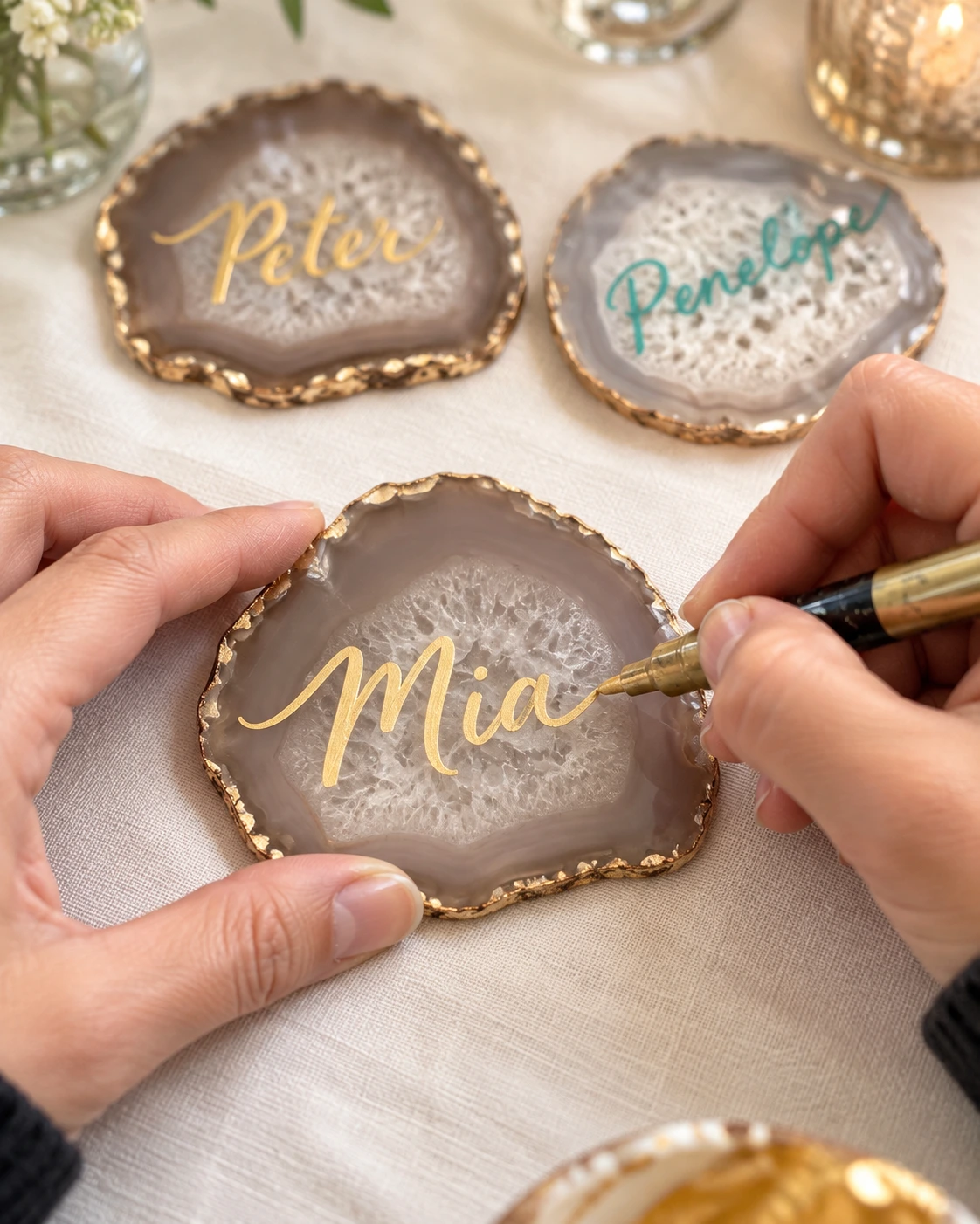 Artist lettering a gold name on an agate keepsake