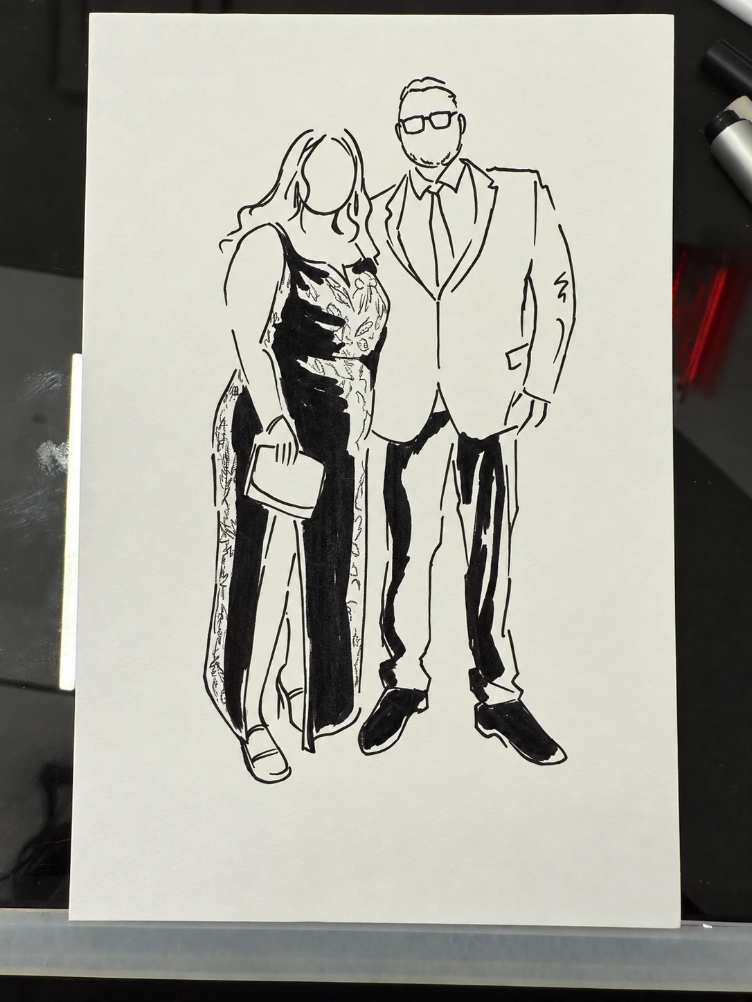 Black-and-white fashion sketch of a couple in formalwear on paper