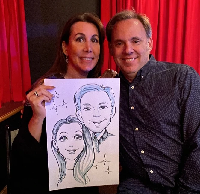 A couple holding their hand-drawn anime-inspired portrait on paper