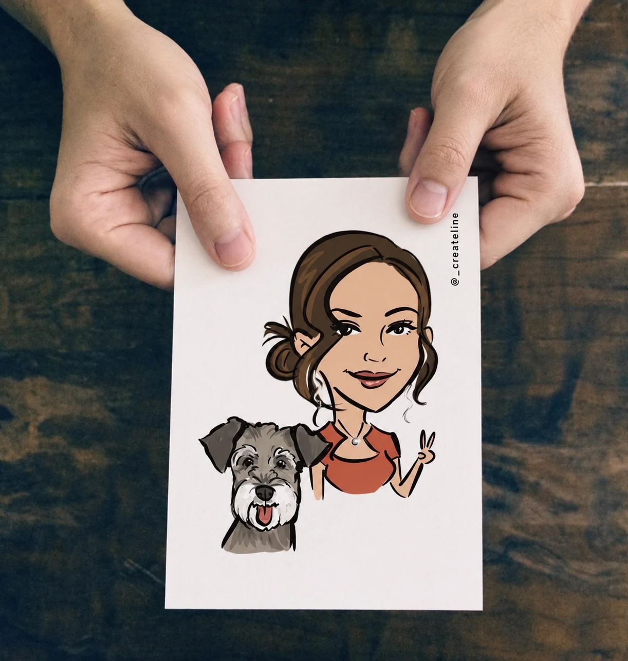 Hands holding a printed CreateLine portrait of a woman and her dog