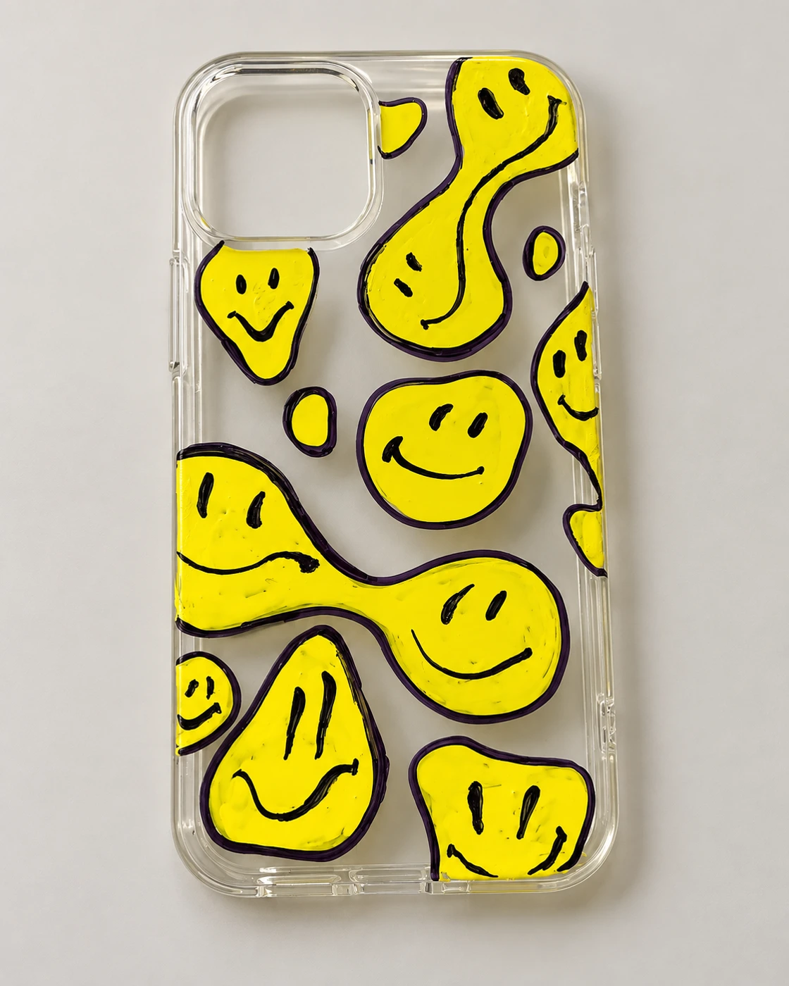 Clear phone case decorated with yellow smiley-face art