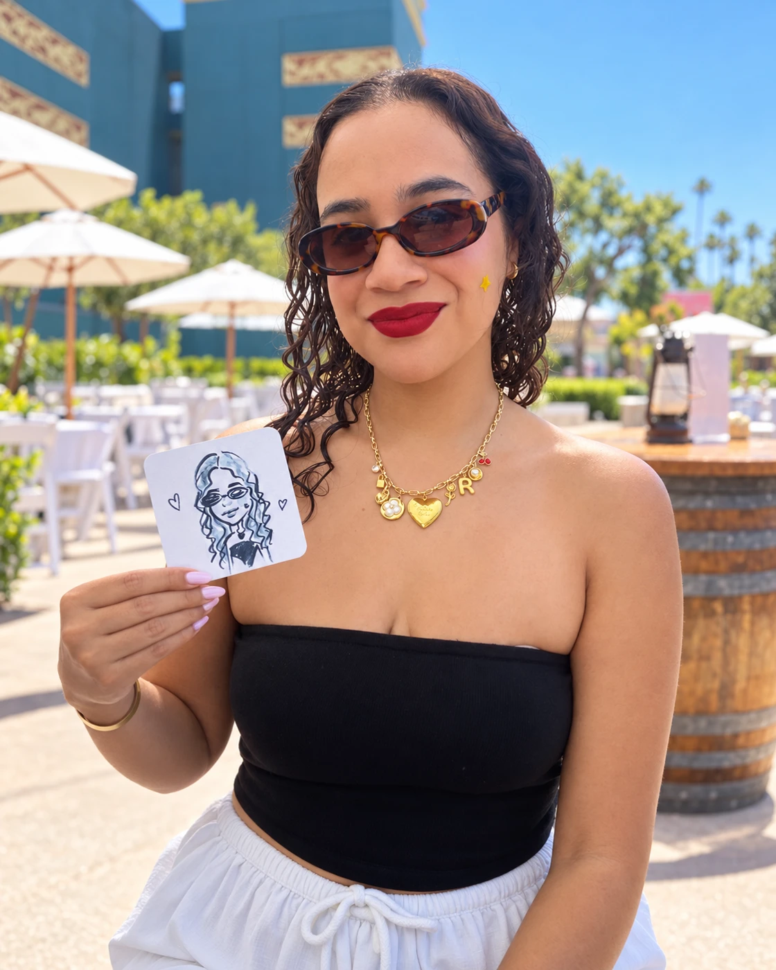 Guest in a black top holding her portrait coaster