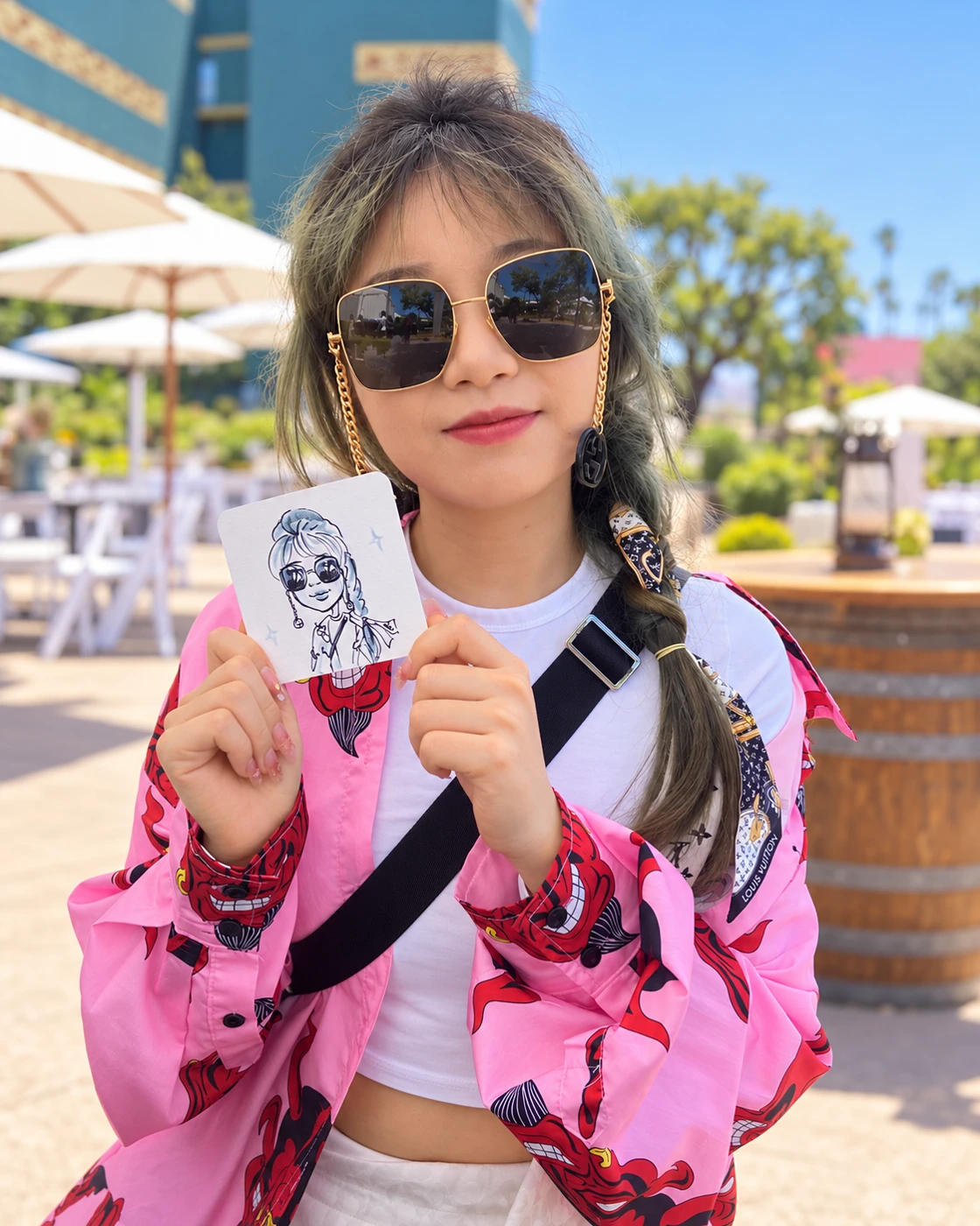 Guest in a pink jacket holding her portrait coaster