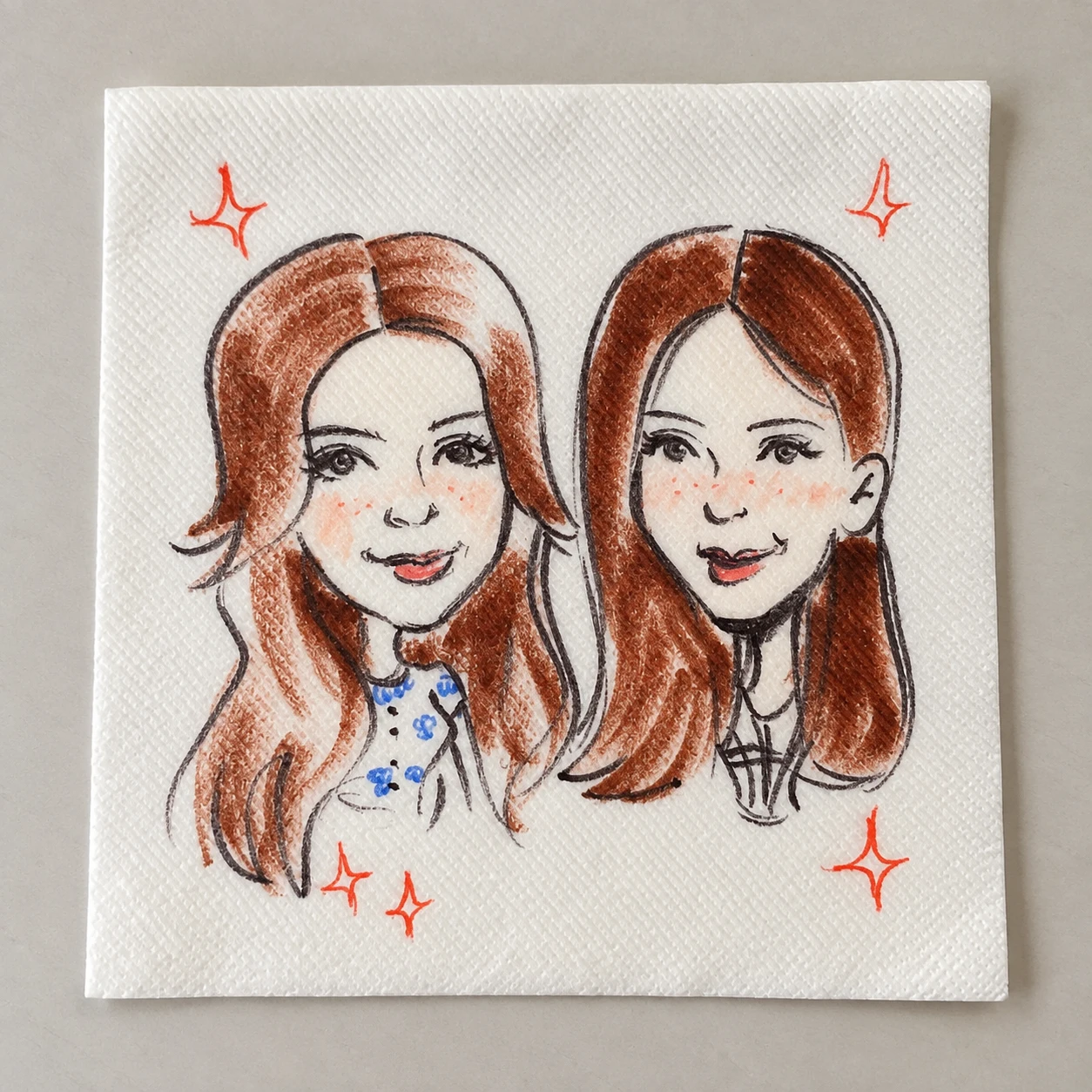 Two women drawn together on a cocktail napkin